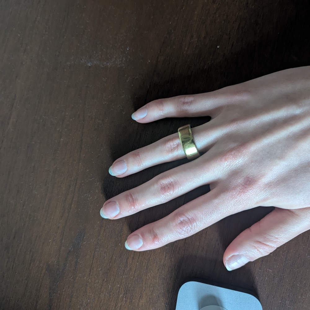 Oura Smart Ring charging dock - white and gold accents